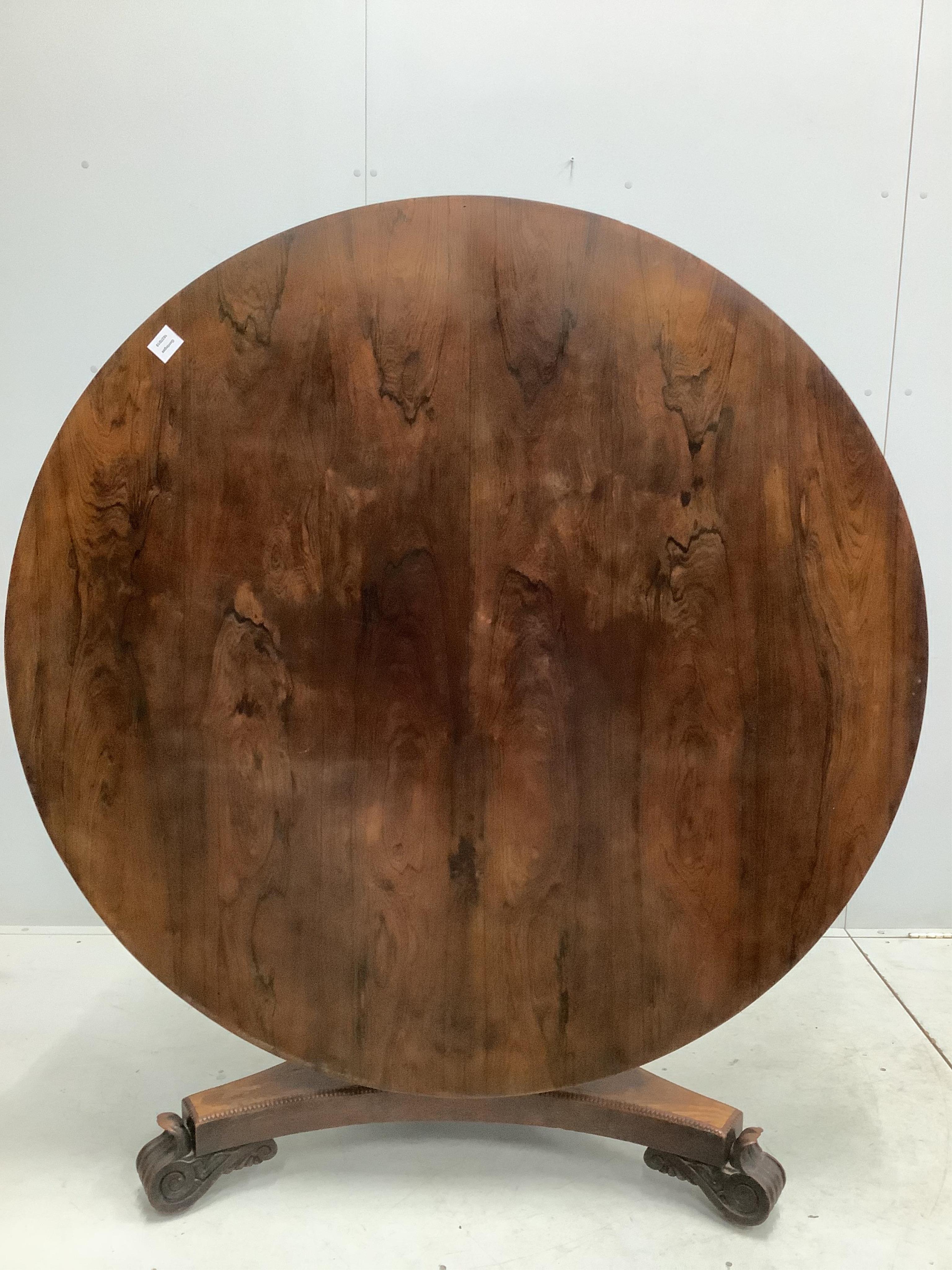 A Victorian rosewood circular tilt top breakfast table, diameter 135cm, height 72cm. Condition - poor to fair, triangular plinth base has lost approximately 10% of veneer